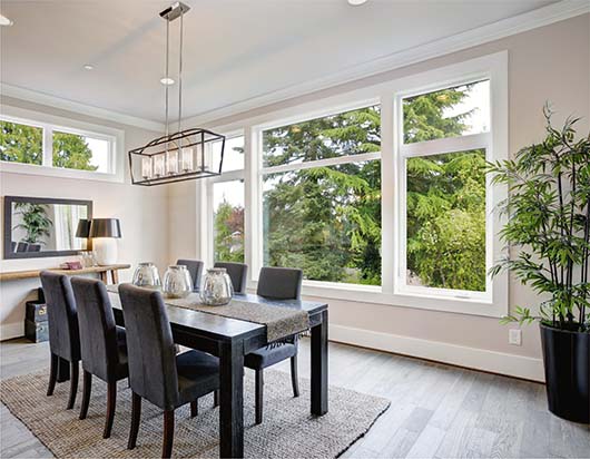 A dining room table looking out through a set of glass windows.