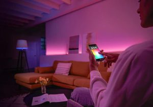 A home equipped with smart lighting be controlled by a man via a phone app. 